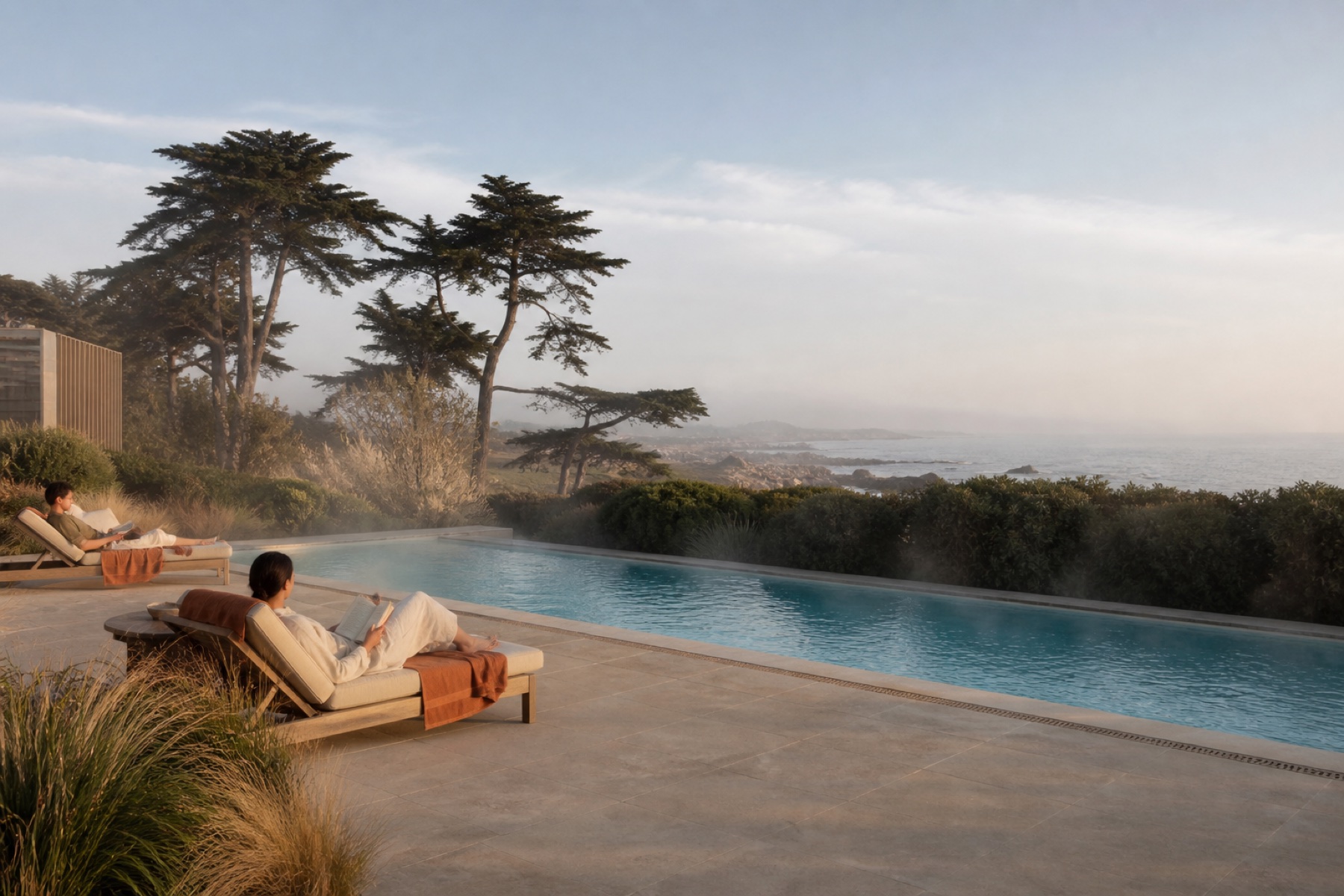 Heated pool facing a quiet cypress-lined coast with guests reading